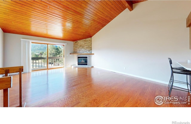 unfurnished living room featuring a fireplace, wooden ceiling, vaulted ceiling with beams, and light hardwood / wood-style flooring