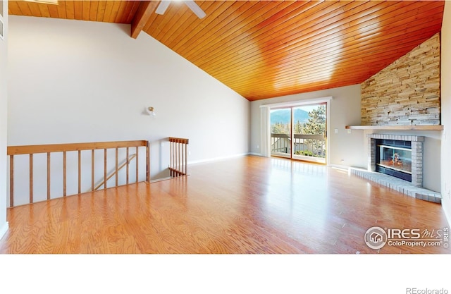 unfurnished living room featuring wooden ceiling, light hardwood / wood-style floors, ceiling fan, beam ceiling, and a large fireplace