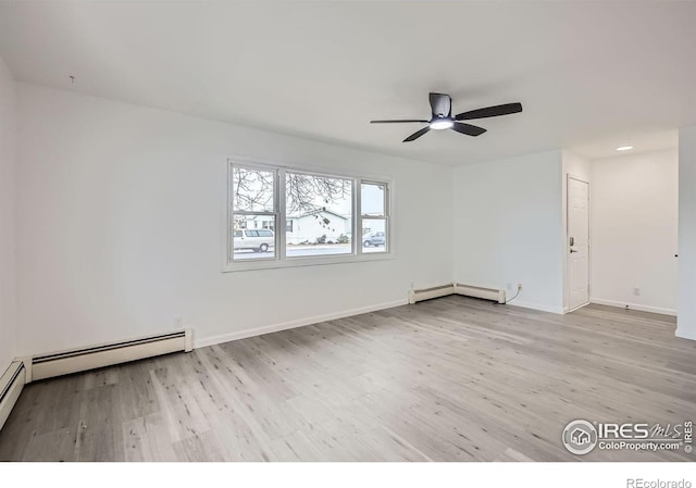 spare room with a baseboard heating unit, ceiling fan, and light wood-type flooring