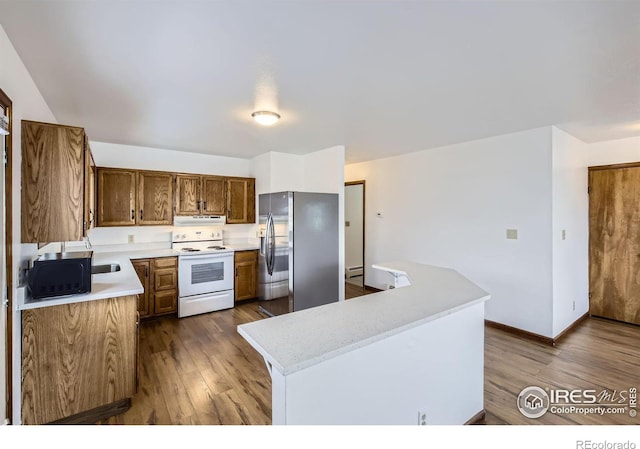 kitchen featuring dark wood-type flooring, exhaust hood, a baseboard radiator, stainless steel fridge with ice dispenser, and white range with electric cooktop