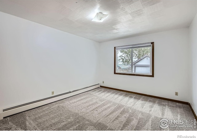 carpeted spare room with a baseboard radiator