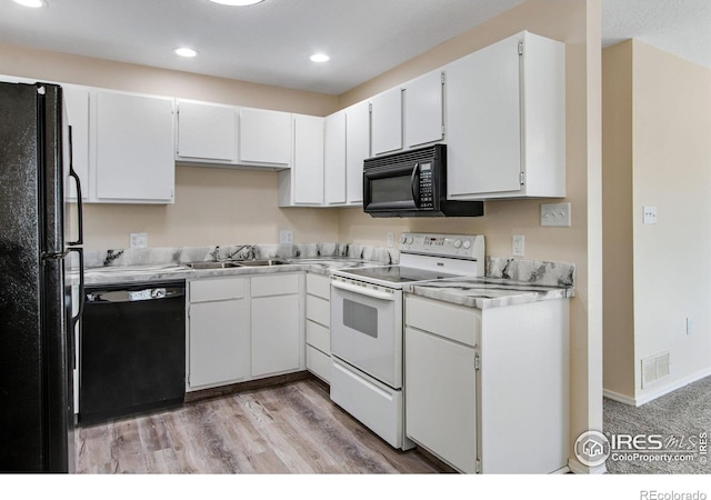 kitchen with white cabinets, light hardwood / wood-style flooring, black appliances, and sink