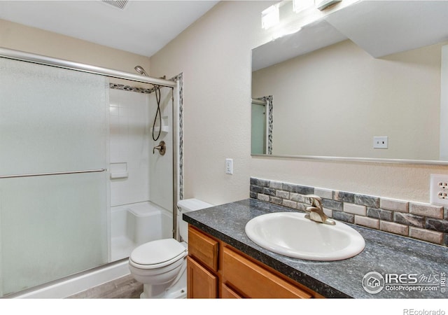 bathroom with a shower with shower door, vanity, toilet, and wood-type flooring