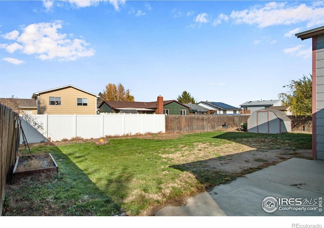 view of yard with a storage unit and a patio