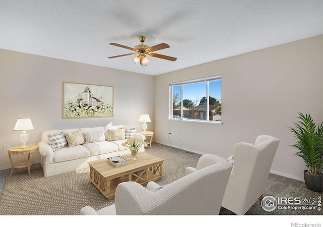 carpeted living room featuring ceiling fan and a textured ceiling