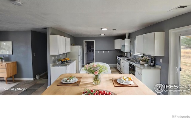 18542 County Road 8, Wiggins, CO 80654 - kitchen with gas range, freestanding refrigerator, white cabinets, and baseboards
