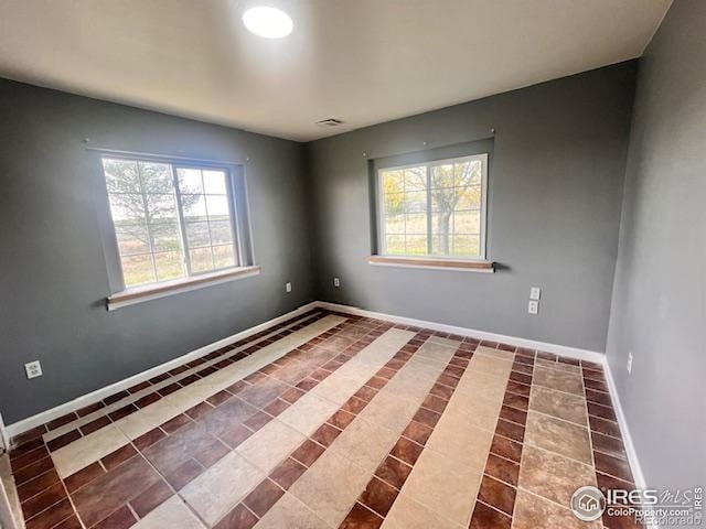 18542 County Road 8, Wiggins, CO 80654 - unfurnished room with plenty of natural light, tile patterned flooring, and baseboards