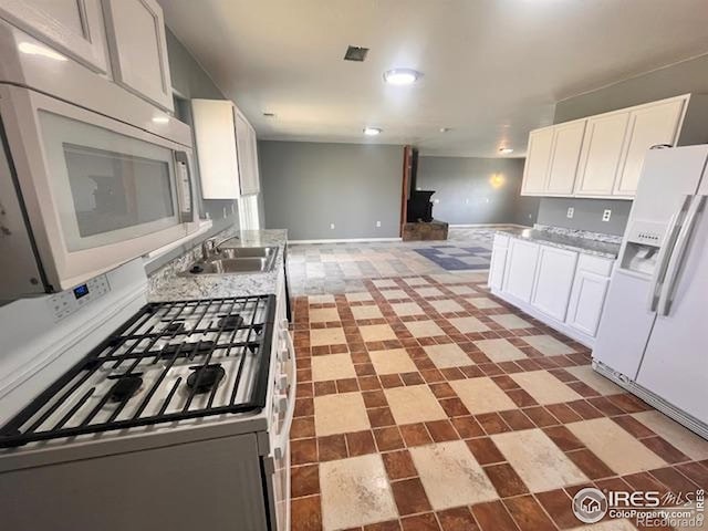 18542 County Road 8, Wiggins, CO 80654 - kitchen featuring white appliances, a sink, white cabinetry, light countertops, and baseboards