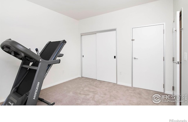 exercise room featuring light carpet