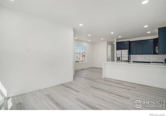 kitchen featuring light hardwood / wood-style floors, backsplash, and appliances with stainless steel finishes