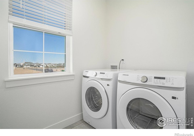 clothes washing area with separate washer and dryer and light tile patterned floors