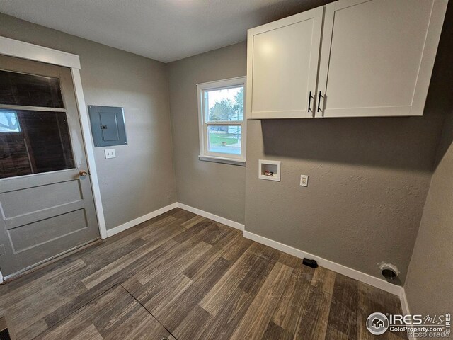 laundry area featuring electric panel, cabinets, hookup for a washing machine, and dark wood-type flooring