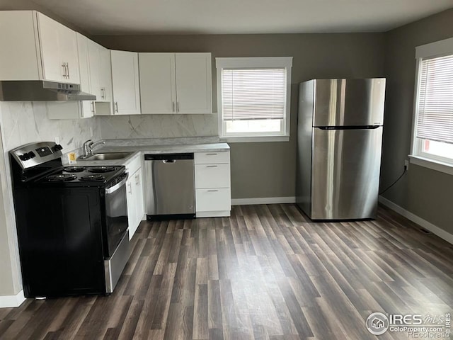 kitchen featuring backsplash, dark wood-type flooring, white cabinets, sink, and appliances with stainless steel finishes