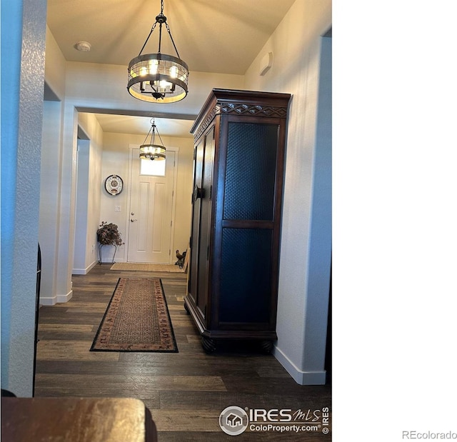 hall featuring dark hardwood / wood-style floors and a notable chandelier