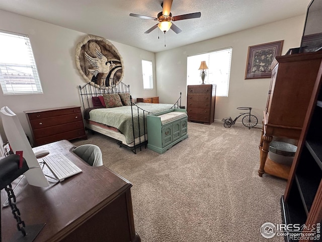 carpeted bedroom with ceiling fan and a textured ceiling