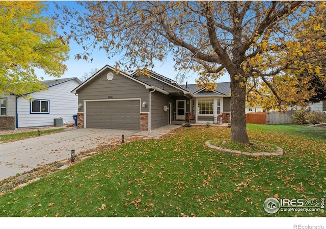 view of front of property with a garage, cooling unit, and a front yard