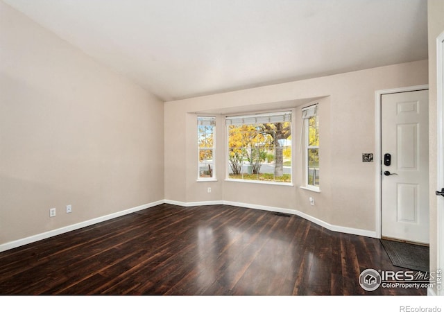 spare room featuring dark wood-type flooring