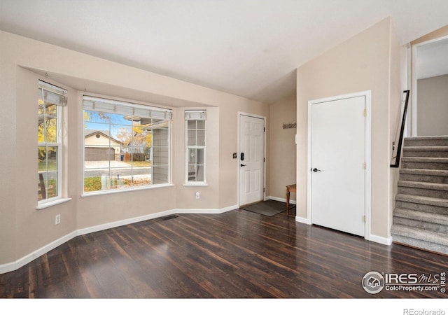 foyer featuring dark hardwood / wood-style flooring and lofted ceiling