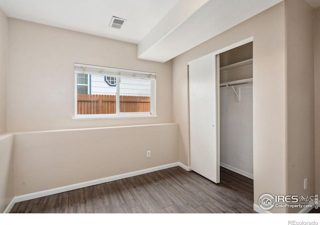 unfurnished bedroom with a closet and wood-type flooring