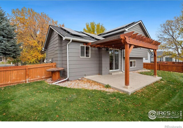 rear view of house featuring solar panels, a lawn, a pergola, and a patio area