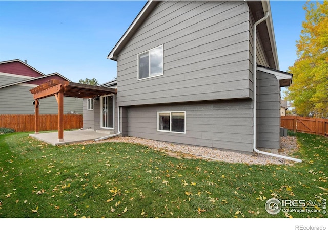 back of house featuring a lawn, a pergola, and a patio area