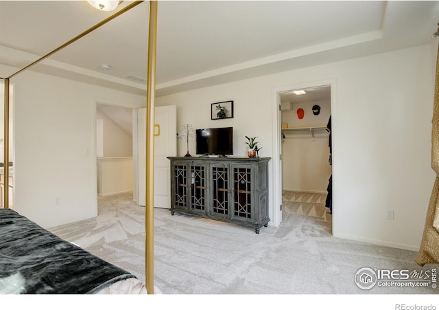 bedroom with a closet, a spacious closet, and light carpet