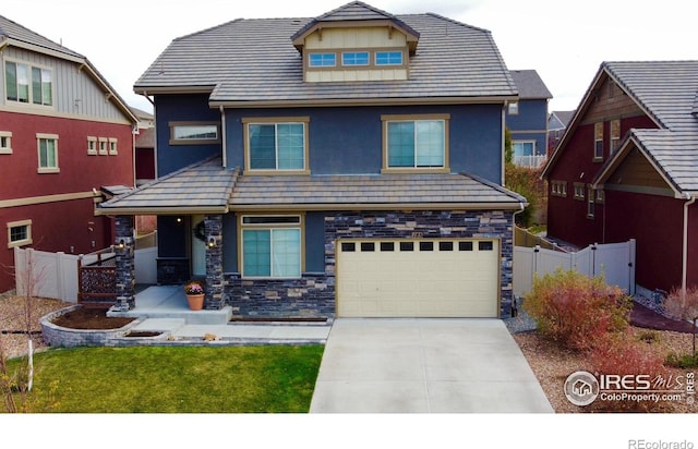 185 Pipit Lake Way, Erie, CO 80516 - view of front of property with an attached garage, driveway, stone siding, and stucco siding