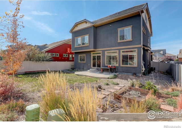 185 Pipit Lake Way, Erie, CO 80516 - rear view of house featuring a vegetable garden, entry steps, a fenced backyard, and a patio area