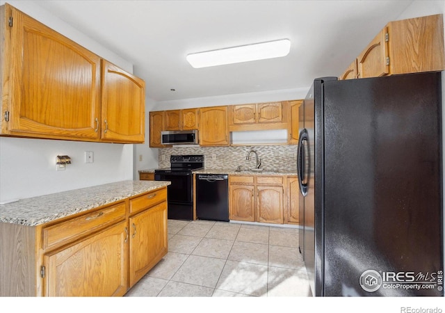 kitchen with black appliances, sink, tasteful backsplash, and light tile patterned floors