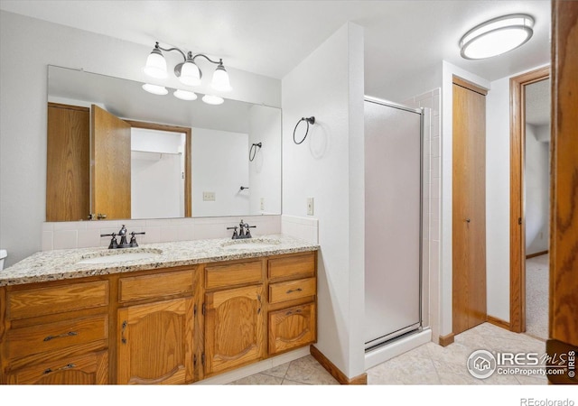 bathroom featuring tile patterned floors, vanity, and a shower with door