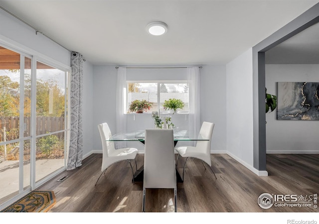 dining room with a wealth of natural light and dark hardwood / wood-style floors