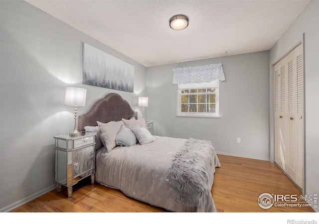 bedroom with a closet, a textured ceiling, and hardwood / wood-style flooring