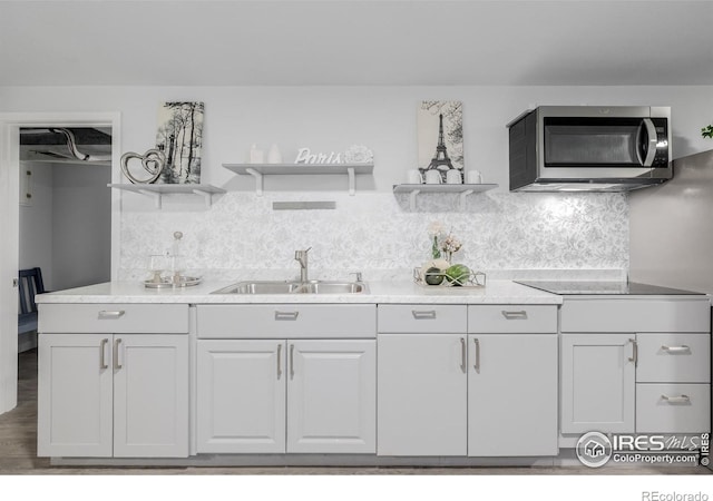 kitchen with white cabinets, hardwood / wood-style flooring, decorative backsplash, and sink