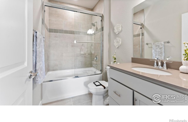 full bathroom with toilet, combined bath / shower with glass door, vanity, and tile patterned floors