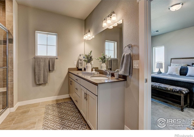 bathroom with tile patterned flooring, plenty of natural light, vanity, and a shower with shower door