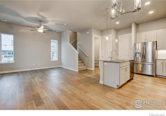 kitchen with plenty of natural light, white cabinetry, a center island with sink, and stainless steel appliances