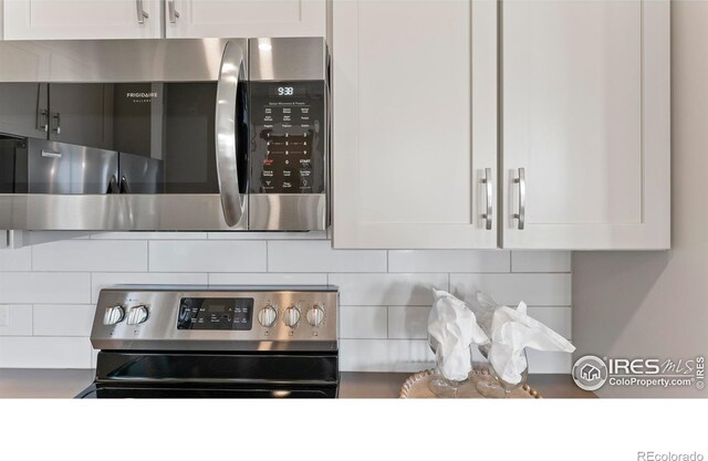 kitchen with white cabinets, decorative backsplash, and stainless steel appliances