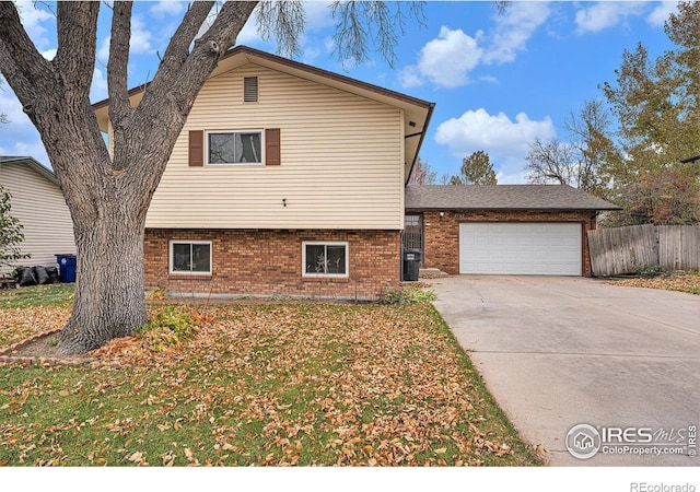 split level home featuring a garage and a front lawn