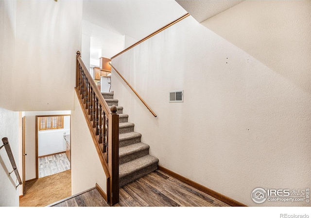 stairs featuring hardwood / wood-style floors