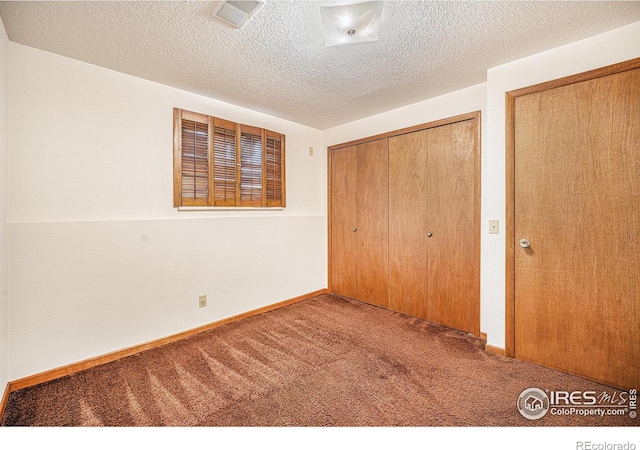 unfurnished bedroom featuring carpet and a textured ceiling