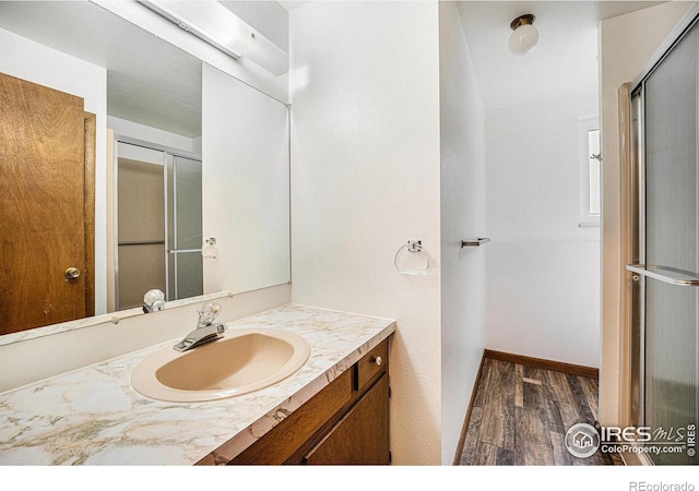 bathroom featuring wood-type flooring, vanity, and a shower with door