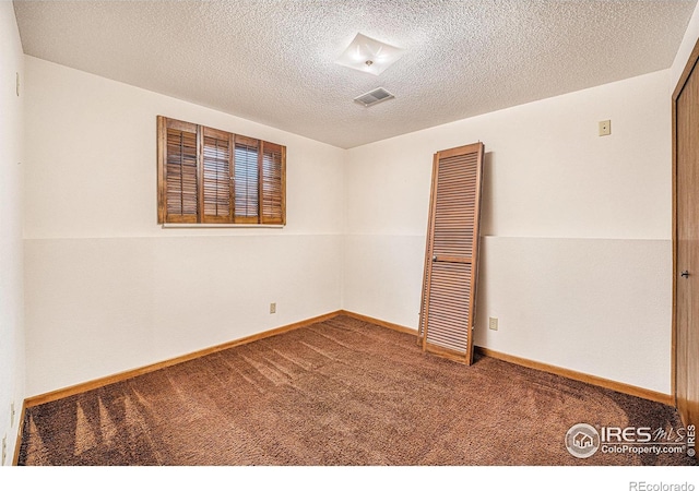 carpeted spare room featuring a textured ceiling