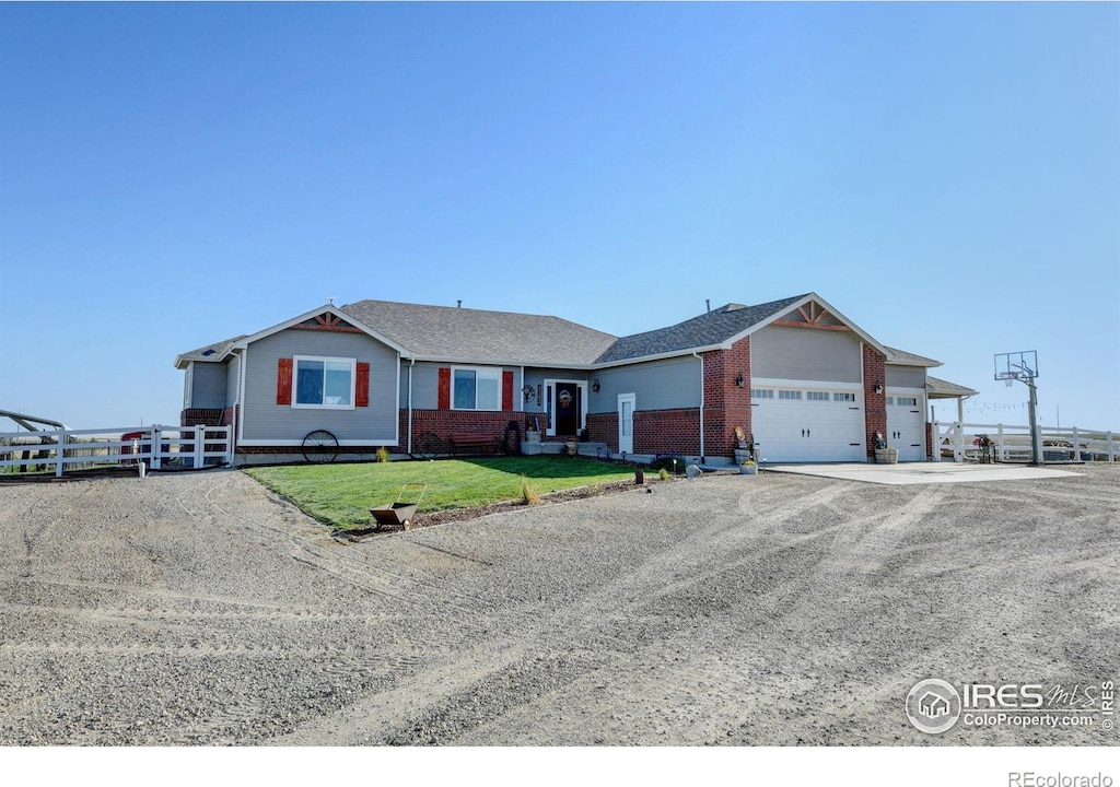 1583 County Road 83, Roggen, CO 80652 - ranch-style house with an attached garage, driveway, and brick siding