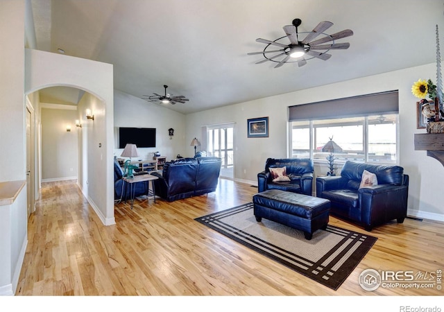 living room featuring light hardwood / wood-style flooring, lofted ceiling, and ceiling fan