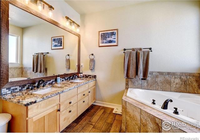 bathroom featuring vanity, hardwood / wood-style floors, and tiled tub