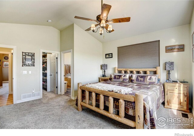 carpeted bedroom featuring a closet, vaulted ceiling, ceiling fan, and ensuite bath