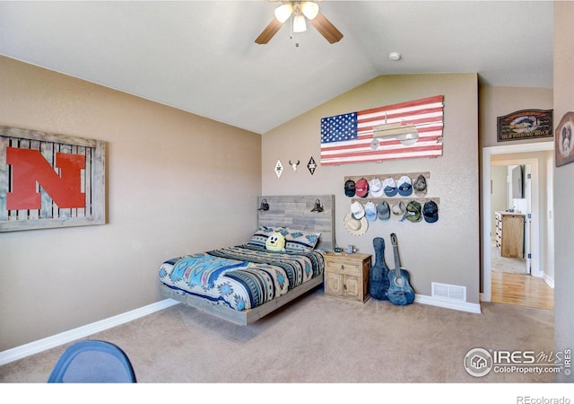 carpeted bedroom with ceiling fan and vaulted ceiling