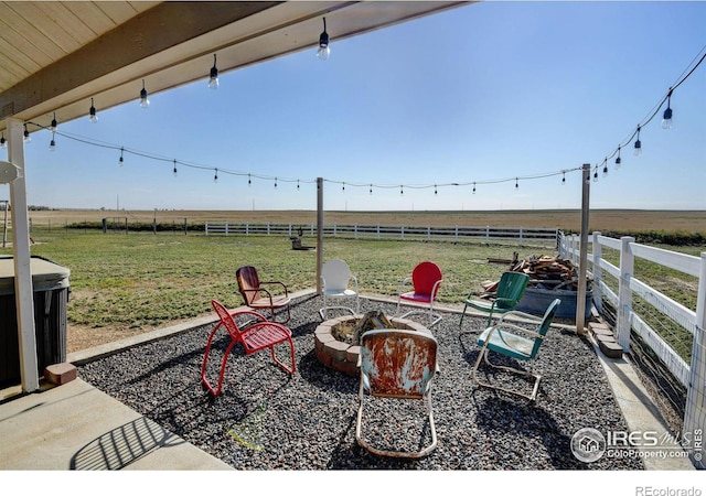 view of patio with a rural view and a fire pit