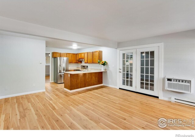 kitchen with light hardwood / wood-style flooring, kitchen peninsula, stainless steel refrigerator with ice dispenser, a wall unit AC, and a baseboard radiator