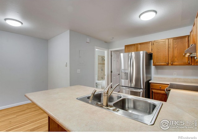 kitchen with appliances with stainless steel finishes, light hardwood / wood-style flooring, and sink